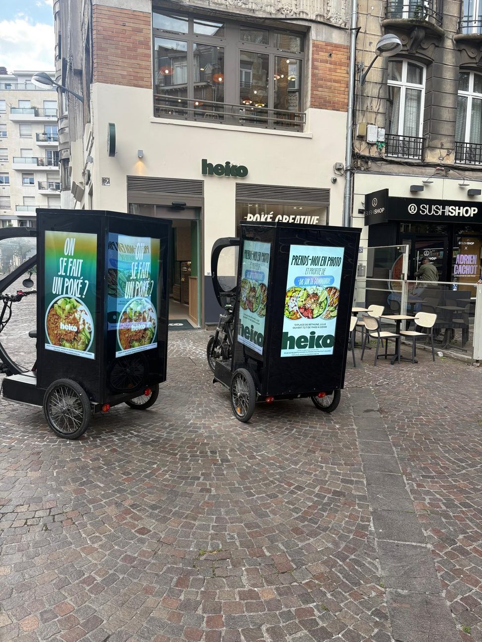 Vélos publicitaires LED Média Move devant des commerces